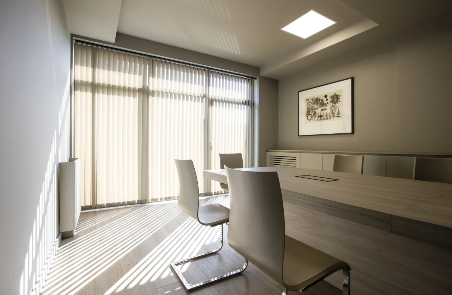 Modernes Konferenzzimmer mit klarer Ton in Ton Gestaltung und Vertikal-Jalousien